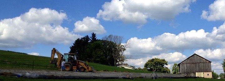 photo of a septic system being installed on a farm next to a barn